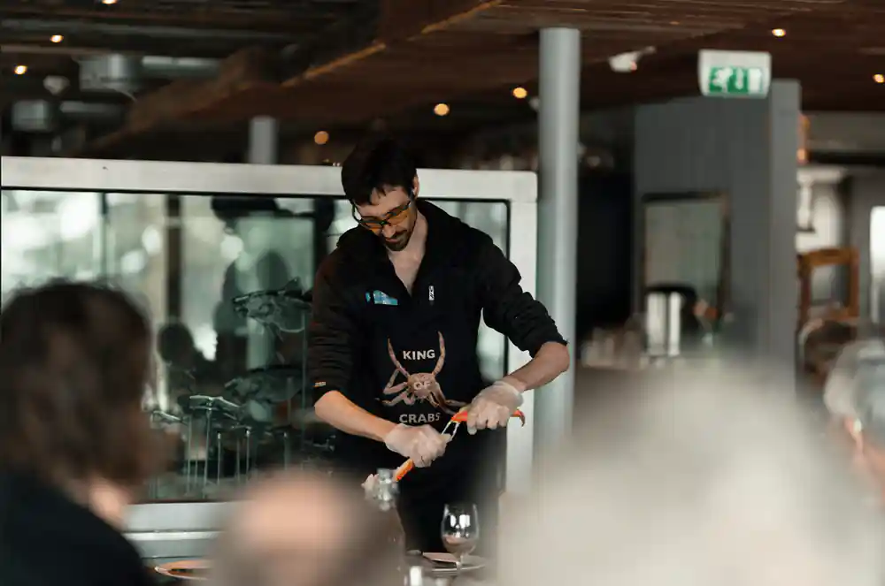 Staff member preparing crab inside the boathouse restaurant