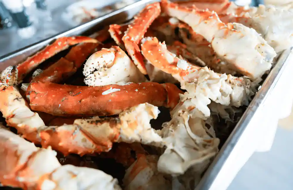 A tray heaped with split king crab legs ready to eat